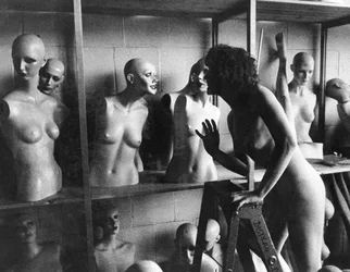 Estados Unidos: c.1966 Uma mulher nua em uma escada conversa com uma cabeça de manequim.